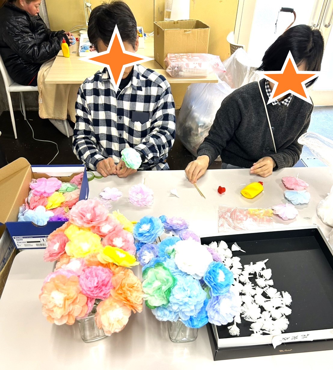 就Bの作業場で色とりどりの紙の花を作成中